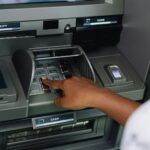 Person using an ATM machine with a credit card to withdraw cash advance