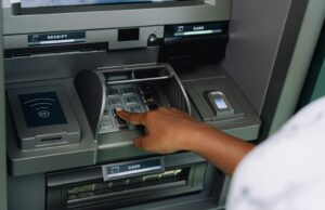 Person using an ATM machine with a credit card to withdraw cash advance