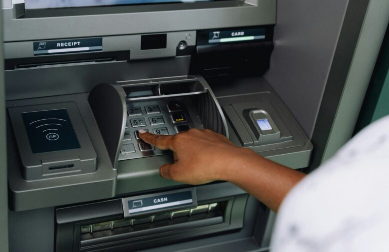 Person using an ATM machine with a credit card to withdraw cash advance