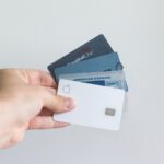Person holding several credit cards, representing authorized user credit building