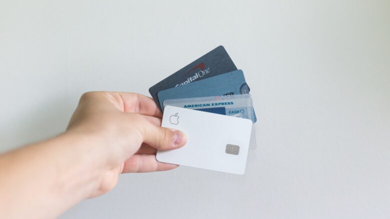 Person holding several credit cards, representing authorized user credit building