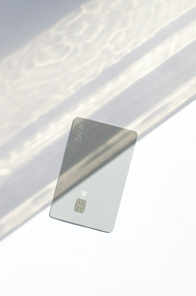 Silver credit card resting on a table, representing a first starter card for building credit