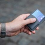 Person holding a credit card, representing steps to rebuild credit after missed payments