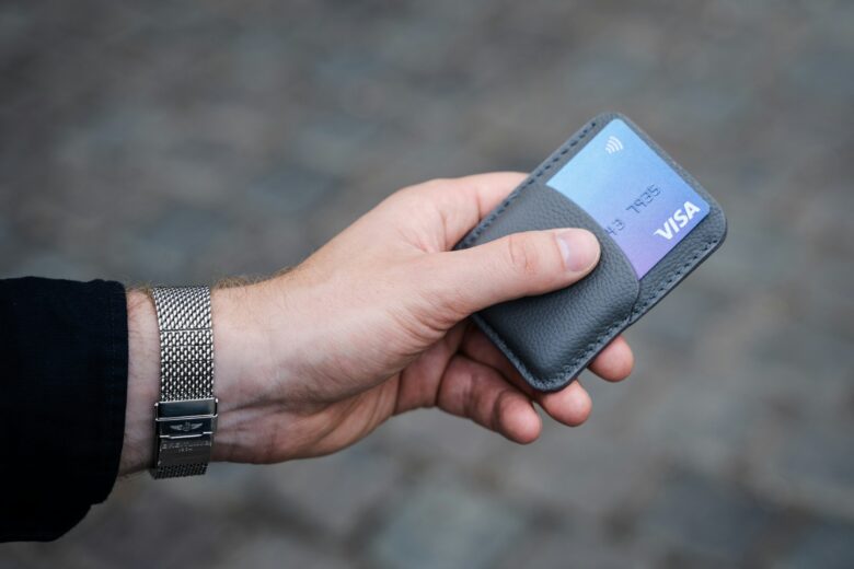 Person holding a credit card, representing steps to rebuild credit after missed payments