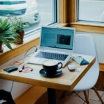 Freelancer working on a laptop with coffee, representing gig work and irregular income