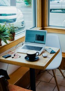 Freelancer working on a laptop with coffee, representing gig work and irregular income