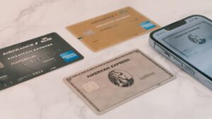 Several credit cards laid out next to a phone, representing comparing no annual fee card options