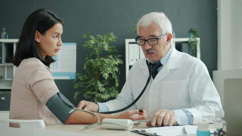 Doctor checking a patient's blood pressure with a stethoscope, representing a medical visit that can lead to a bill